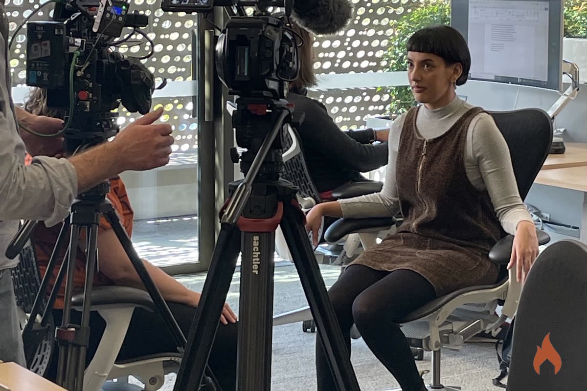 Cinema camera framed on an actor seated in an office chair