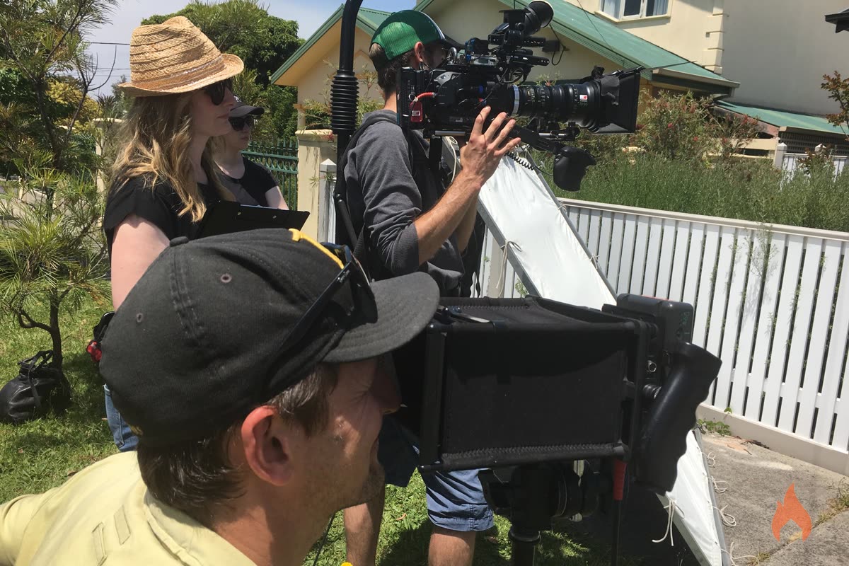 Outdoor shoot with camera operator, reflector and crew in the sunshine